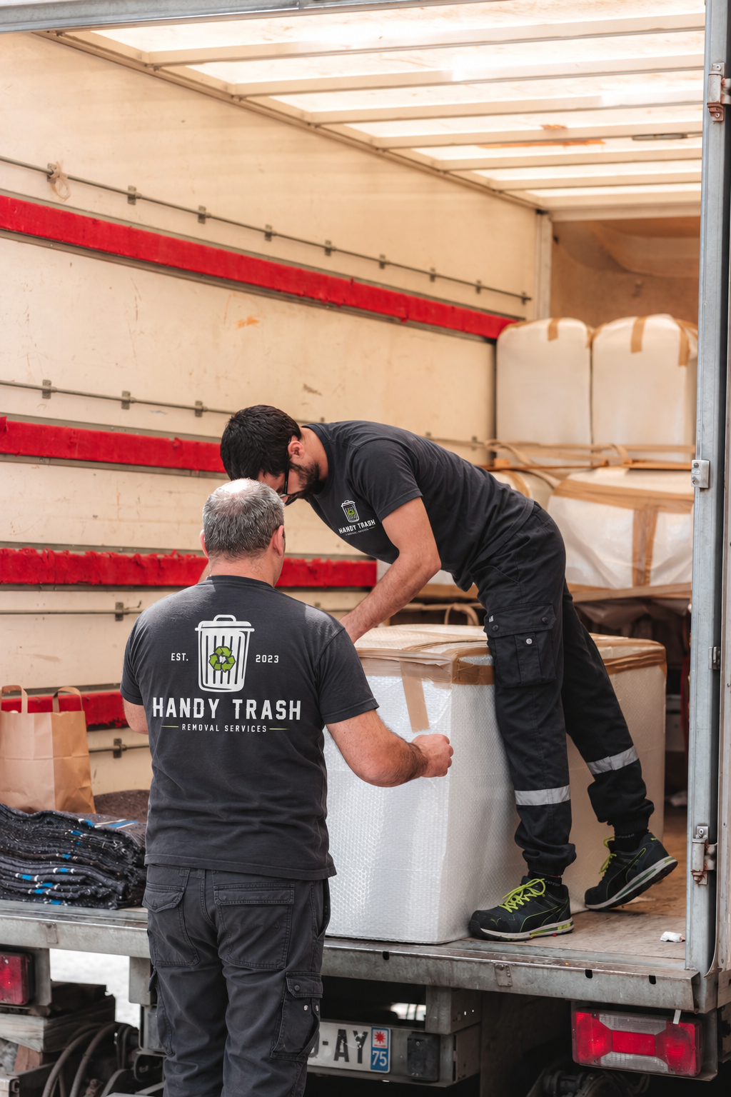 Workers unloading and moving large boxes